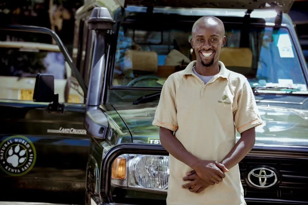 Safari guide standing beside his vehicle